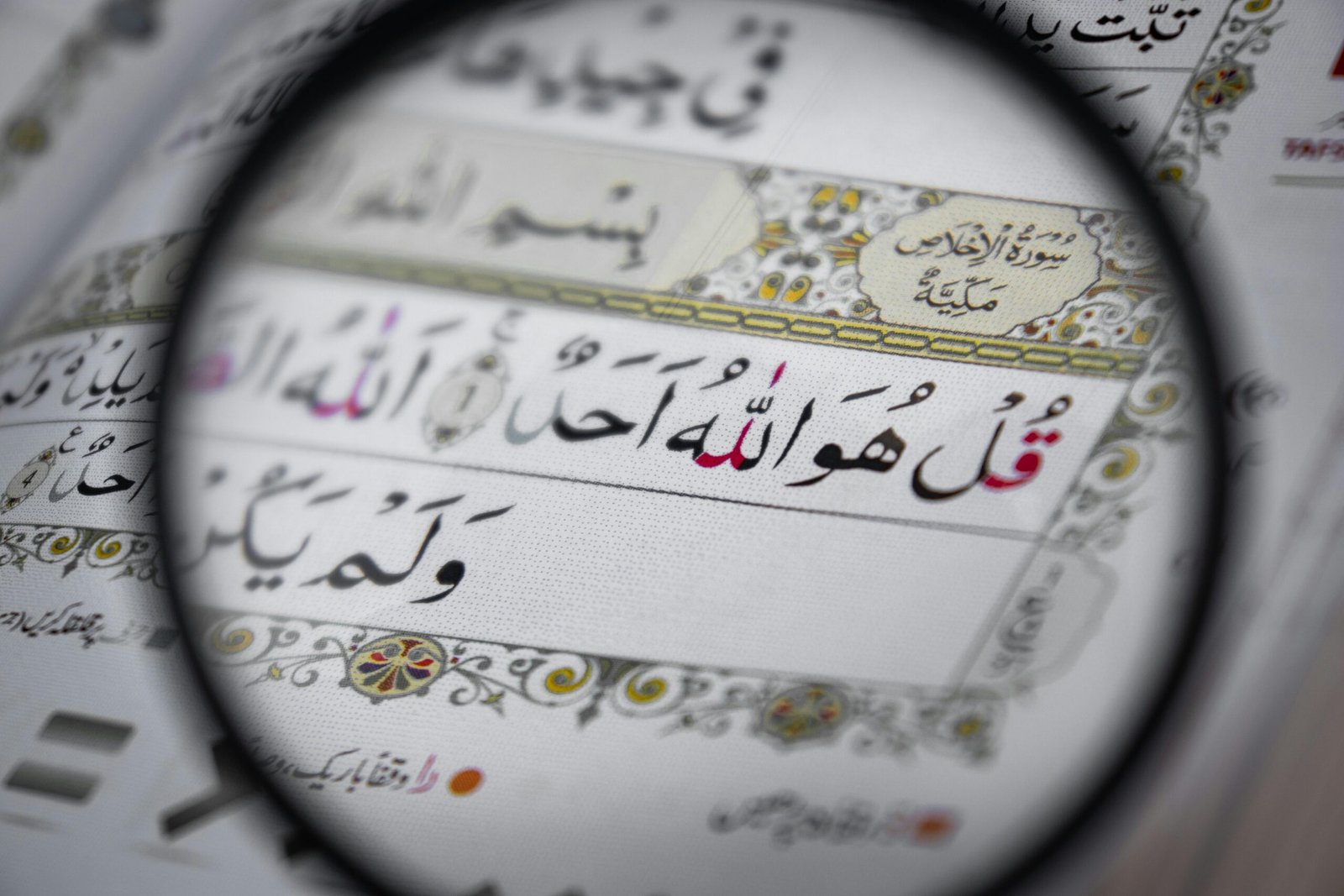 Detailed view of the Quran with intricate Arabic scripts, magnifying religious text and design.